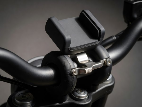 Close-up of motorcycle handlebar smartphone mount showing silicone elastomer vibration dampener ring and locking lever