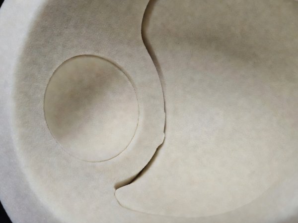 Interior view of motorcycle helmet EPS liner showing circular speaker recess and microphone wire routing channel